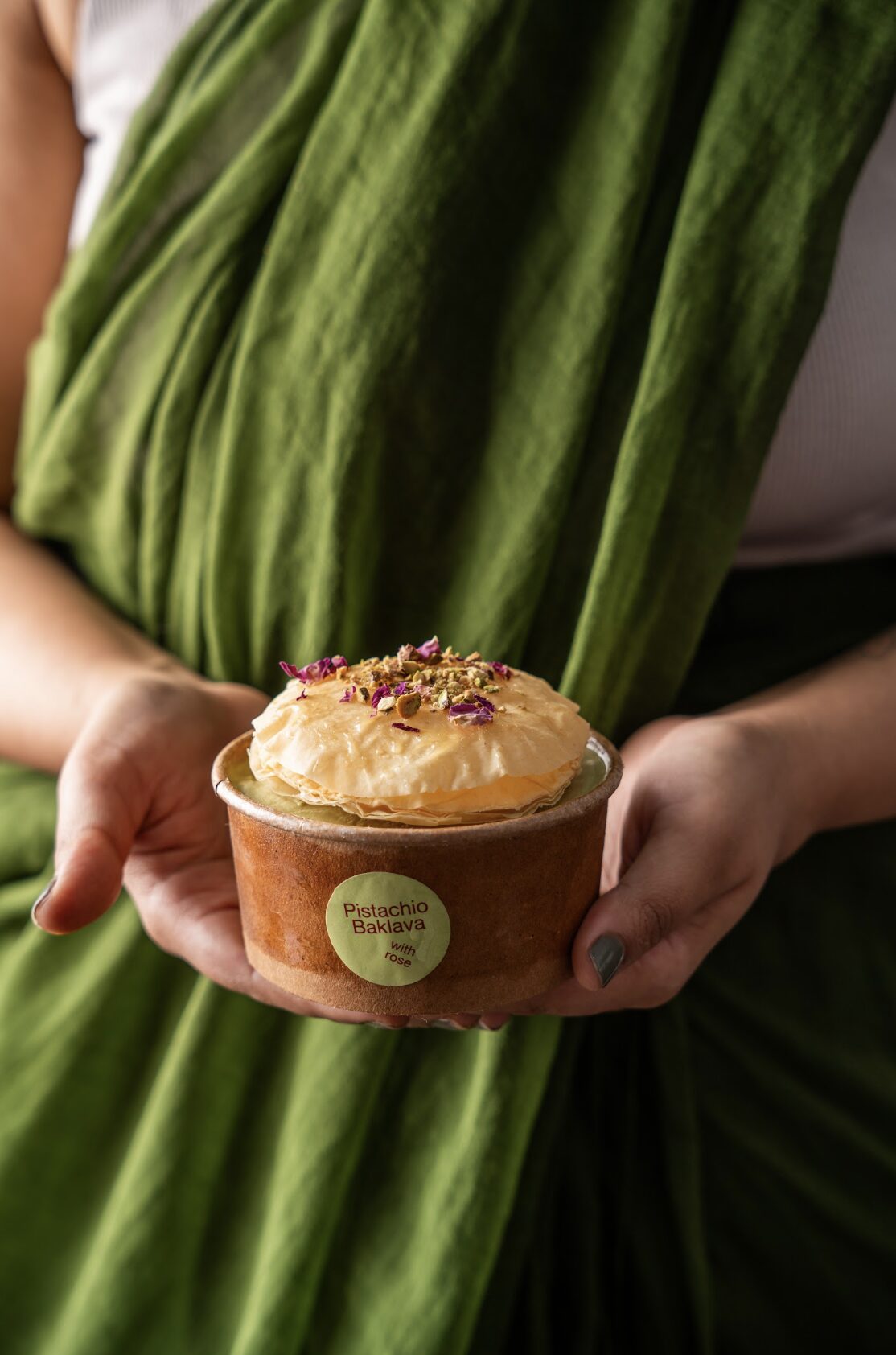 Person in saree holding ice cream tub